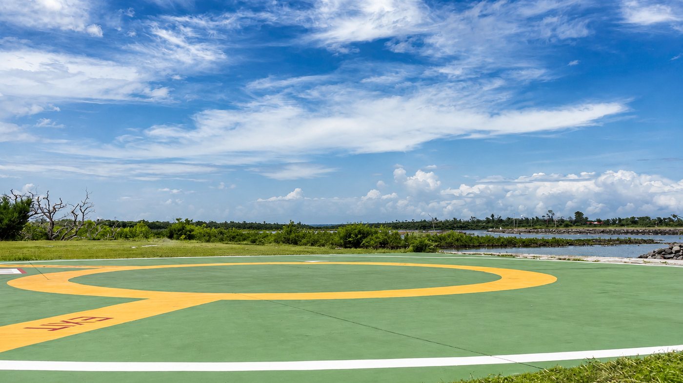 The Benoa helipad — green and yellow markings with the lagoon behind